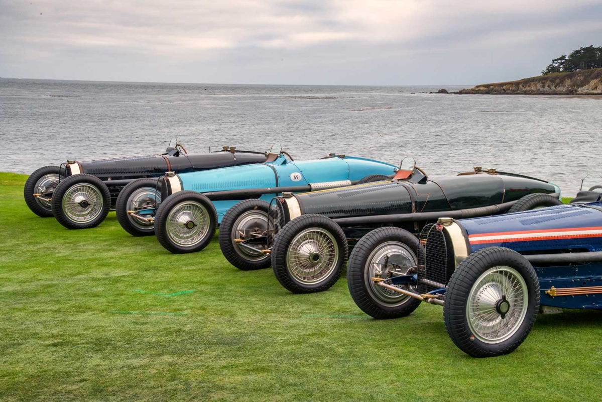 Four Bugattis lined up along the water at the Pebble Beach Concours d'Elegance
