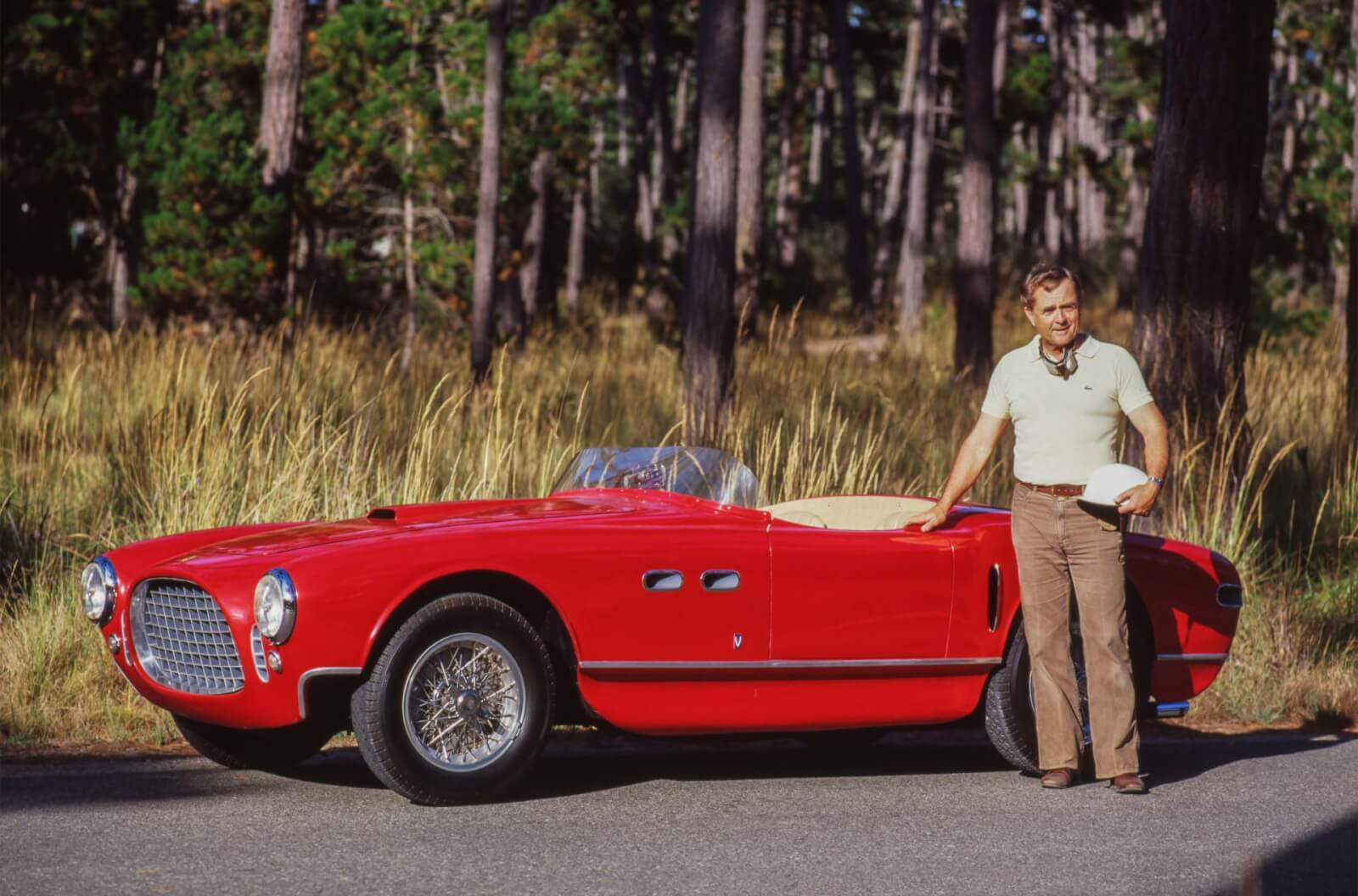 Phil Hill stands beside the Ferrari 250 MM Vignale Spyder he drove to victory in the 1953 Pebble Beach Road Races. 